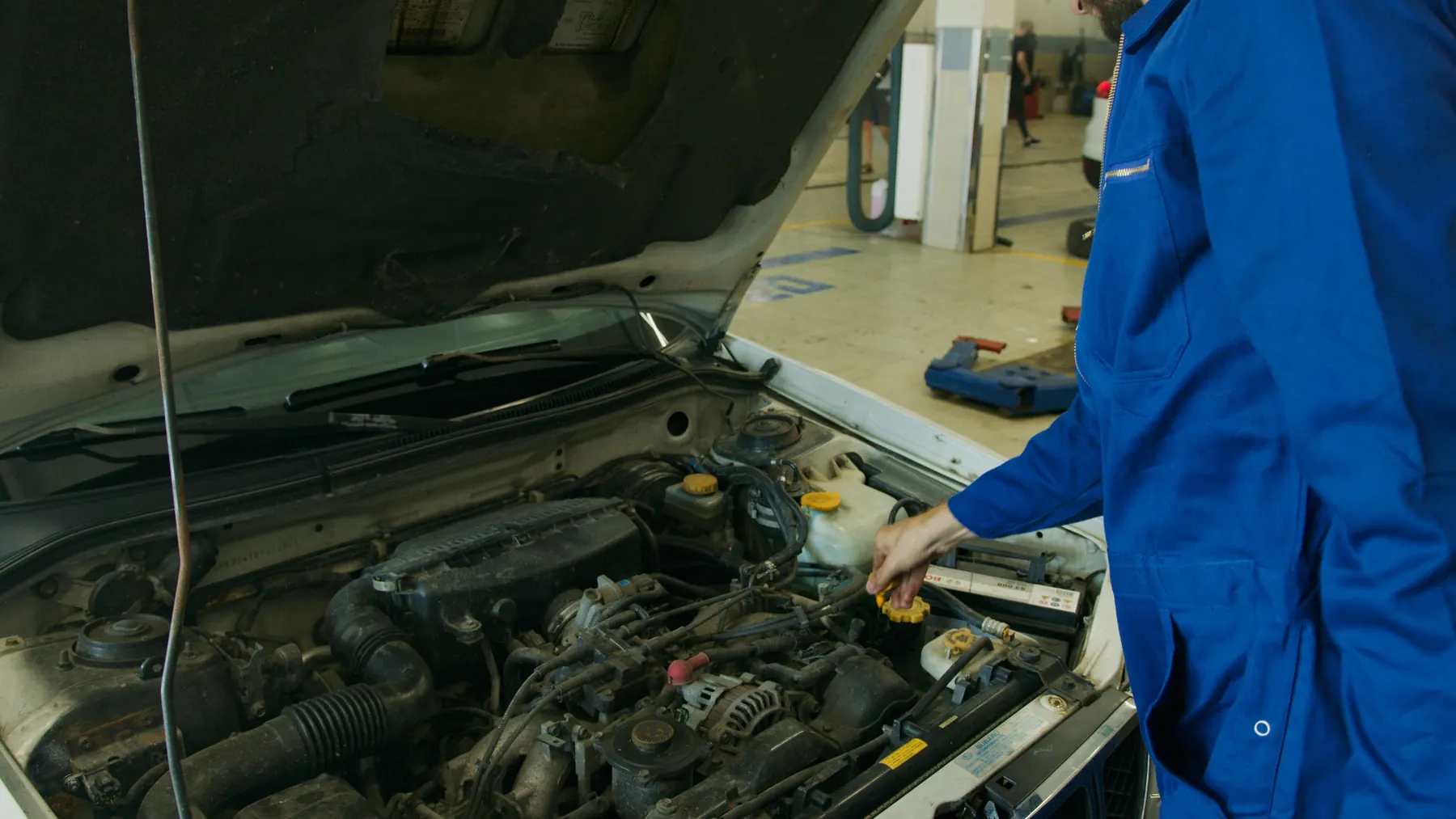 Mechanic inspecting an open vehicle engine